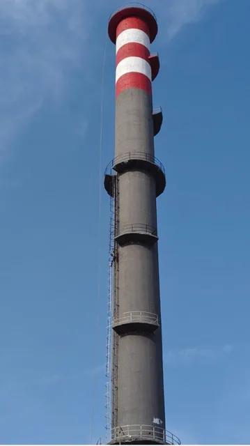 Concrete chimney shaft with circular platforms and red-and-white top bands.