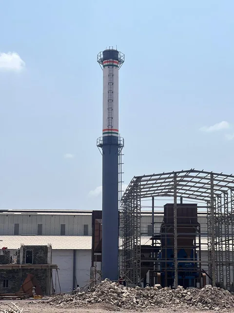 Industrial chimney beside a building structure at a project site.
